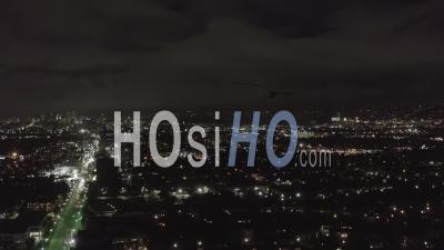 Over Dark Hollywood Los Angeles At Night View On Wilshire Blvd With Clouds Over Downtown And City Lights 4k - Video Drone Footage