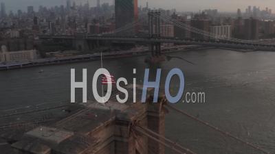 Close Up Of Brooklyn Bridge With American Flag And Beautiful Sunrise Morning Light Over East River In New York City 4k - Video Drone Footage
