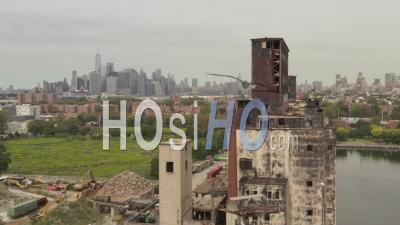 Ascending Dolly Aerial View Of Abandoned Red Hook Grain Terminal In The Harbor With New York City Skyscape In The Background 4k - Video Drone Footage