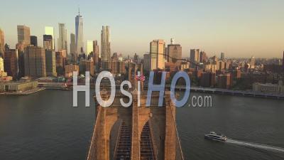 Flight Over Brooklyn Bridge With American Flag Waving And East River View Over Manhattan New York City Skyline In Beautiful 4k - Video Drone Footage