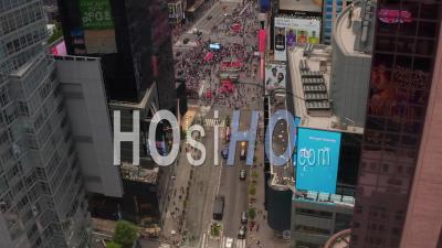 Aerial Shot Descending Between Skyscrapers Of People Walking Towards Times Square Intersection And Empty Surrounding Streets 4k - Video Drone Footage