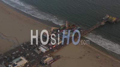 Circling Santa Monica Pier, Los Angeles From Above At Beautiful Sunset With Tourists, Pedestrians Having Fun At Theme Park Ferris Wheel With Ocean View Waves Crashing 4k - Video Drone Footage