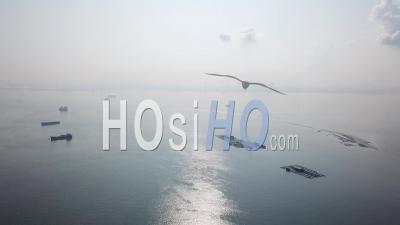 Aerial View Fly Towards The Fish Farm At Sea During Mist Day - Video Drone Footage
