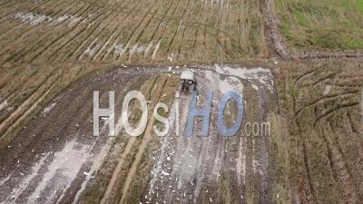 Aerial Tractor Plowing The Muddy Land At The Field. - Video Drone Footage
