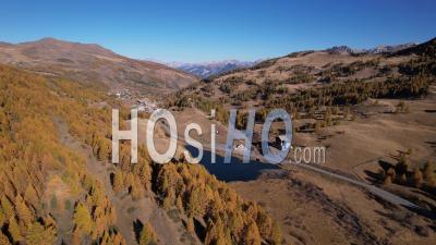 Napoleon Lake And Larch Forest In Autumn Near The Resort Of Vars, Hautes-Alpes, France, Viewed From Drone