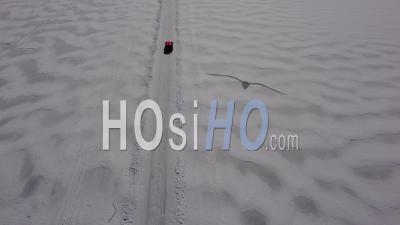 A Car Drives Across A Frozen Lake - Video Drone Footage