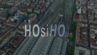 High Angle View Of Commuter Train Leaving Milano Centrale Railway Station. Apartment Buildings In Urban Borough. Milano, Italy - Video Drone Footage