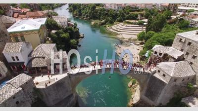 A Bird's-Eye-View Shows Crowds Assembled On The Mostar Bridge And The Neretva River It Passes Over In Mostar, Bosnia - Video Drone Footage