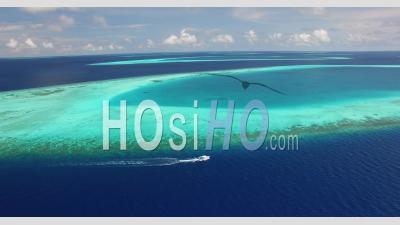An Aerial View Shows A Motorboat Coasting Alongside A Reef In Maldives - Video Drone Footage