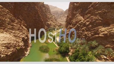 An Aerial View Shows A Waterway And Greenery Between Canyons In Wadi Shab, Oman - Video Drone Footage