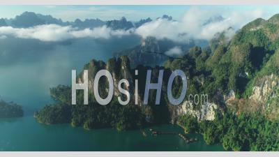 An Aerial View Shows Green Mountains And Harbor Lodgings Among The Clouds At Khao Sok National Park In Surat Thani, Thailand - Video Drone Footage