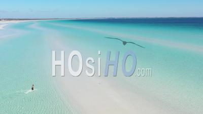 2020 - A Man Running Through The White Sandy Beaches And Clear Blue Water Of Flaherty Beach On Yorke Peninsula, Australia - Video Drone Footage