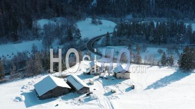 2022 - Excellent Aerial View Of A Car Driving Past Homes In Wintry Landwasser, Switzerland - Video Drone Footage