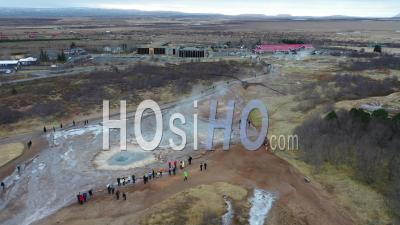 Tourists Watch The Strokkur Geyser Erupt In The Haukadalur Valley Of Iceland - Video Drone Footage