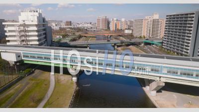 Aerial Of A Train Railway Over The River In Tokyo - Video Drone Footage