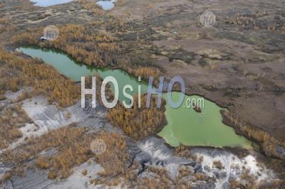 Vue Aérienne Des Arbres D'automne Et D'un Lac Avec De L'eau Verte Dans Une Carrière Abandonnée. - Photographie Aérienne