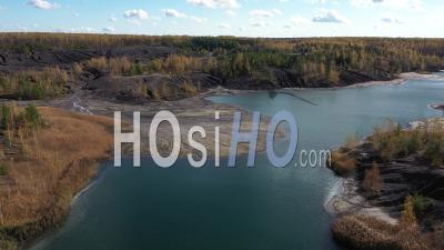 Flying Above The Abandoned Quarry With Forest And Lake In Autumn. - Video Drone Footage