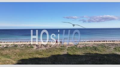 Cycling On The Sea Wall Along The Sea In Mousterlin - Video Drone Footage